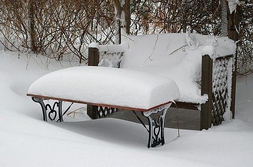 bench and table snow covered in a garden
