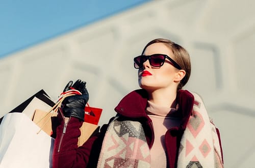 woman with sunglasses wearing luxary clothing, hand gloves and bags