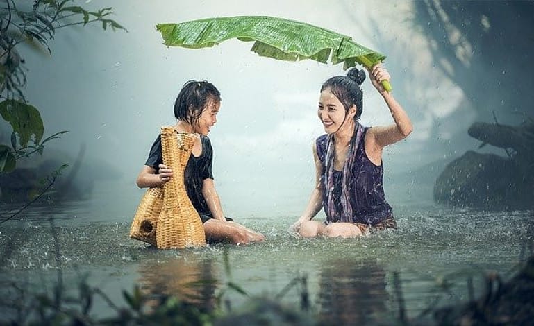 woman and child in lake while it is raining