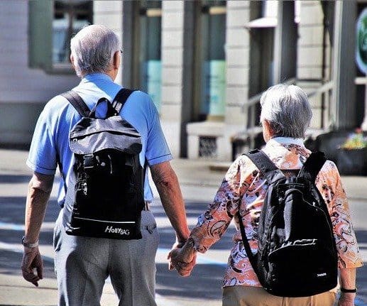 a old couple travelling hand in hand in a city