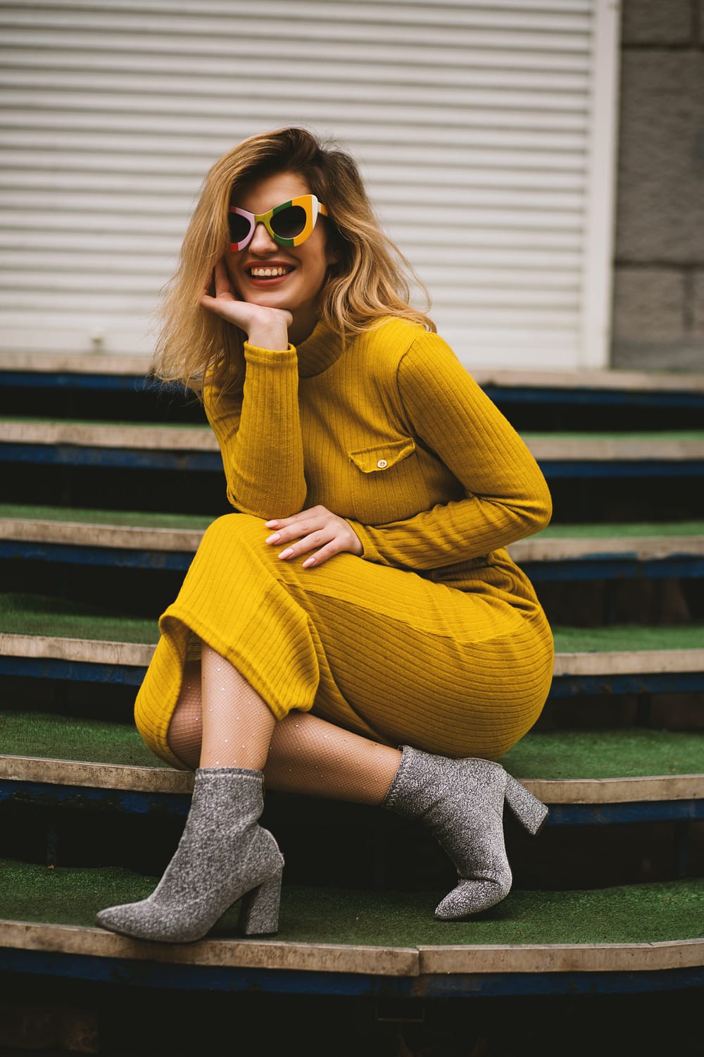 woman in yellow dress, grey boots and yellow sunglasses