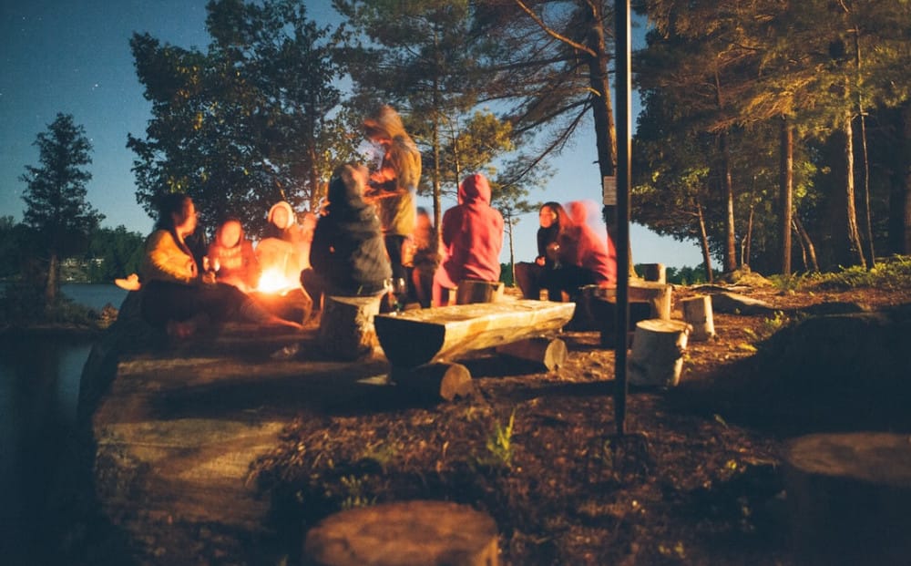 a group of people around a fire, camping