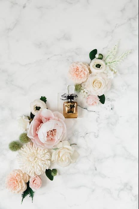 a bottle of perfume between roses