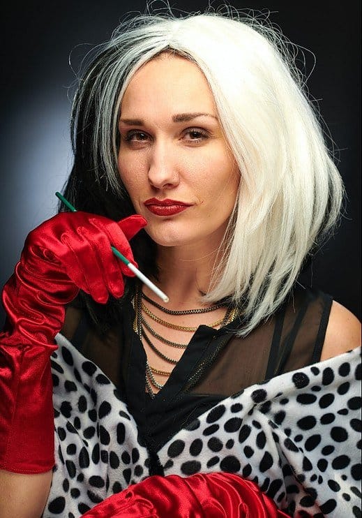 an older woman dressed extravagant with red gloves
