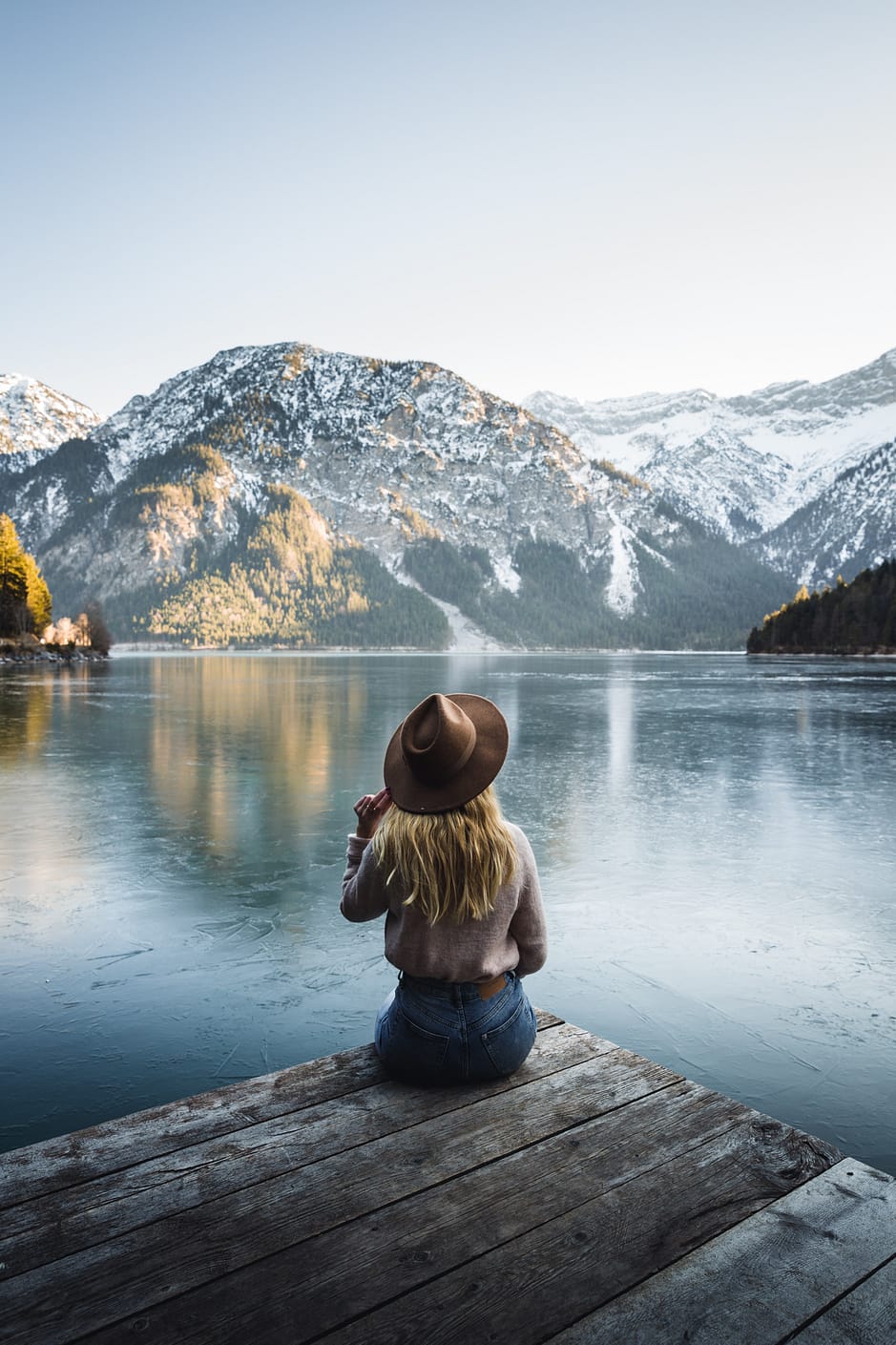 woman sitting beside a lake
